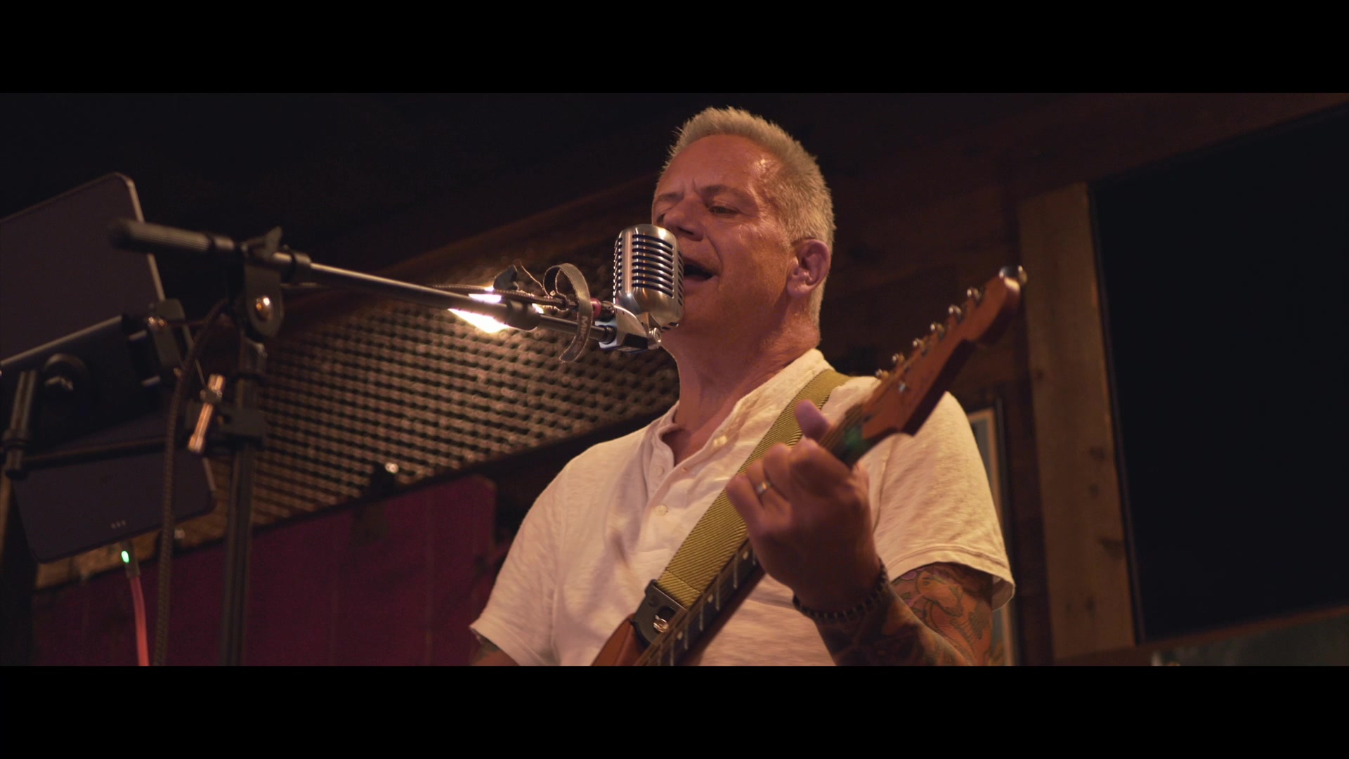 Mike Bush singing into a vintage microphone